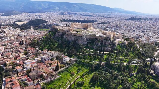 Aerial drone cinematic video above ancient Agora featuring Acropolis hill and the Parthenon, Athens historic centre, Attica, Greece