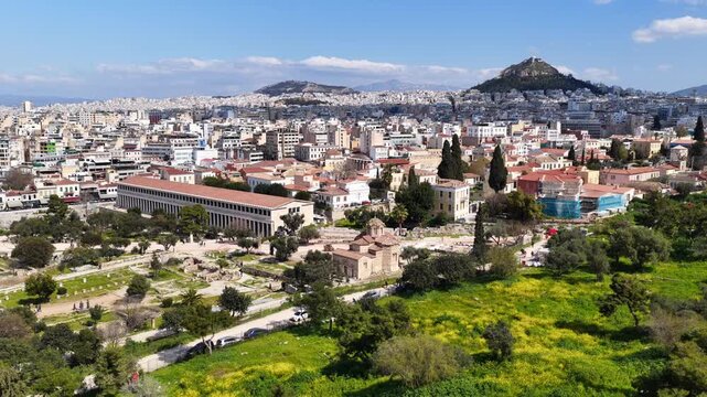 Aerial drone cinematic video of Ancient Agora or Forum of Athens historic centre built below Acropolis hill, Attica, Greece