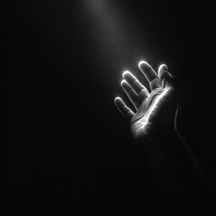 Fototapeta premium Reaching for Light: Hand in Darkness, Monochrome