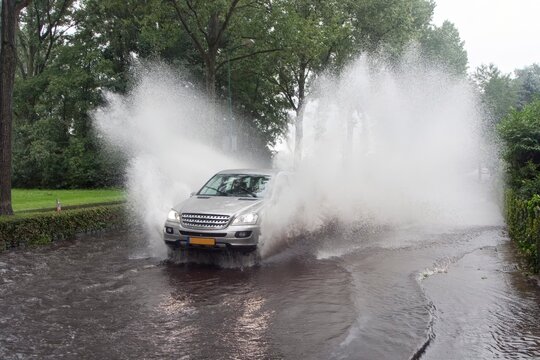 Car driving through a flooded street in the Netherlands