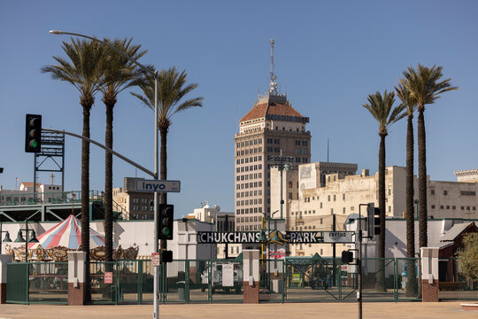 Fresno, California, USA - March 24, 2025: Plam trees frame the downtown Chukchansi Park stadium and skyline.