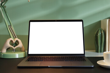 Fototapeta premium Stylish workplace with laptop, decor and cup of coffee on desk indoors, closeup