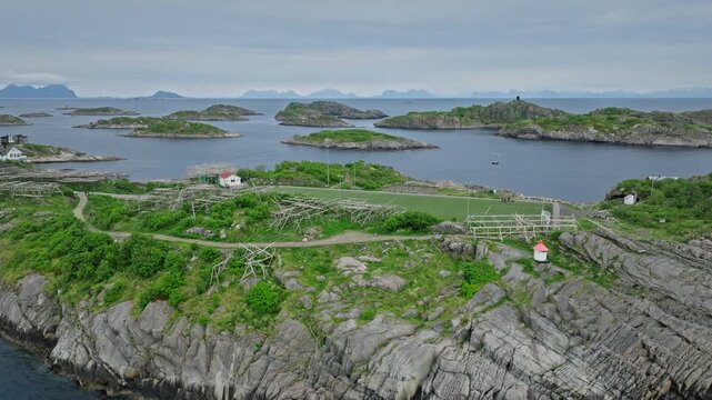Aerial view of Henningsv&aelig;r Football Stadium and traditional stockfish racks in Norway. Scenic Norwegian coastline with large wooden racks used for drying fish.