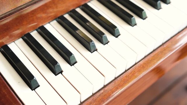 Close up of warm wood piano keys, black and white keys, classic musical instrument detail