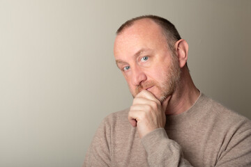 Naklejka premium Middle age, senior man with beard and blue eyes thinking