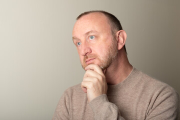 Naklejka premium Middle age, senior man with beard and blue eyes thinking