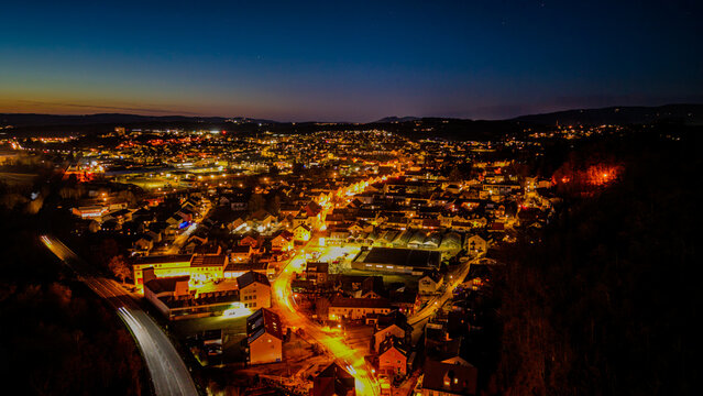 Blick &uuml;ber eine Stadt mit Lichtern in der Nacht und der Dunkelheit am Horizont