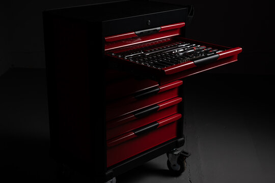 Open red tool chest with organized socket and ratchet tools in workshop