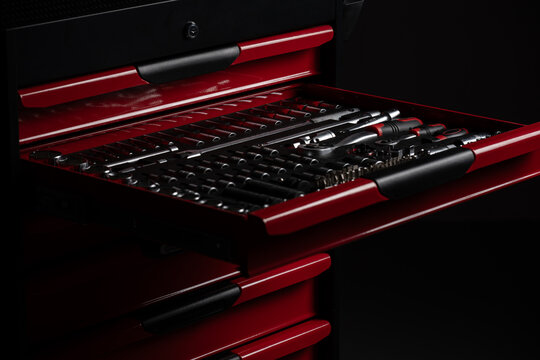 Socket set organized in tool chest drawer in dark workshop