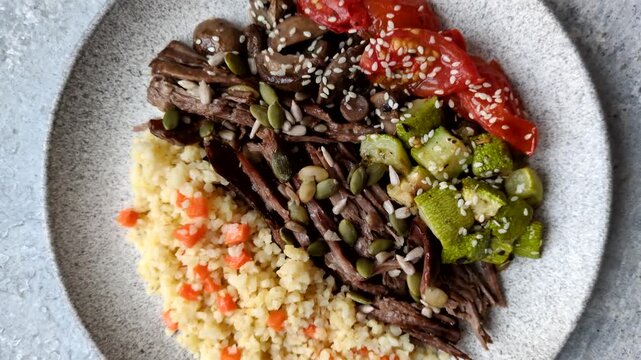 A bowl with beef, porridge, mushrooms, vegetables, sauce, and spices. Beef bowl as a food background for your design