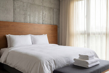 Fototapeta premium Modern bedroom with neatly made bed and wooden headboard