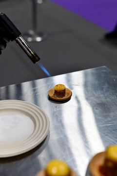 chef elaborando postre con un soplete de reposter&iacute;a para caramelizarlo