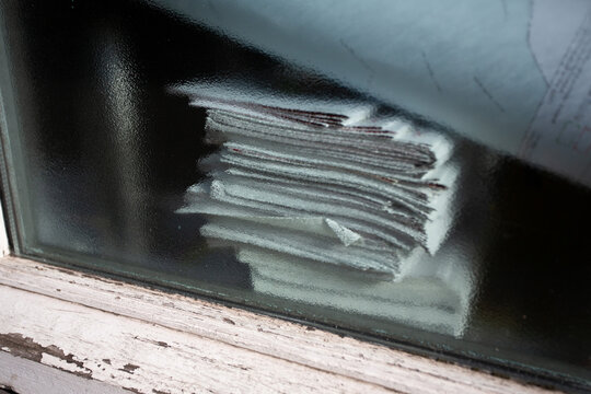 Pile de papiers et documents empil&eacute;s et pos&eacute;s devant une fen&ecirc;tre en attente de traitement