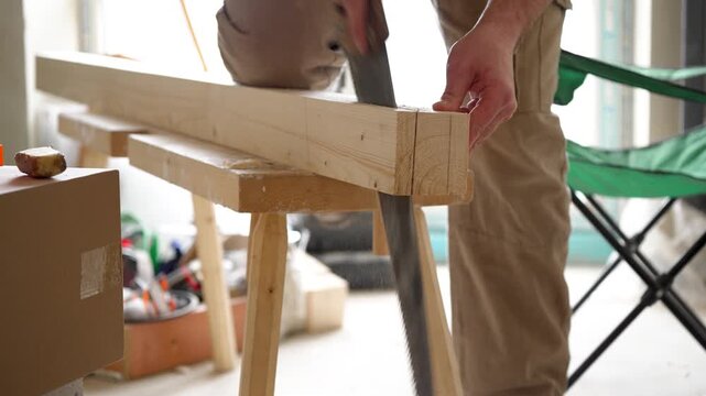 Rhythmic sawing of a wooden beam with a hand saw, scraping sound and wood shavings
