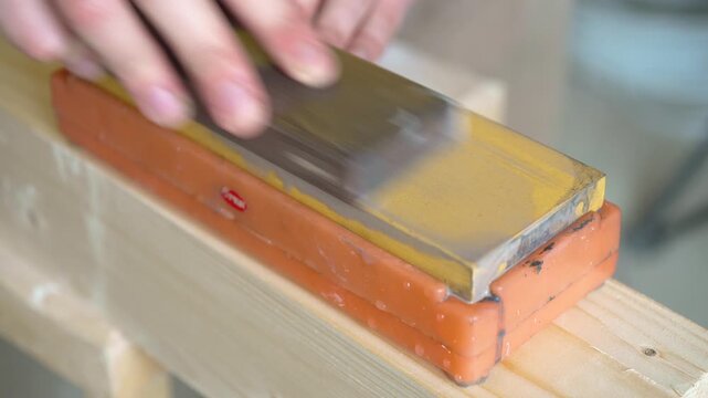 Lapping of a sharpening stone on stone, hoarse hissing sound of grinding
