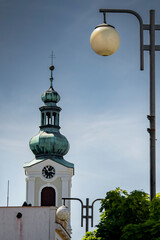 Baroque church tower with green copper dome and street lamp