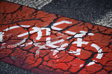 Cracked red running track with faded white lane markings
