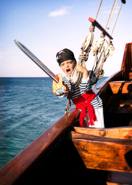 a boy dressed like a pirate on a ship 