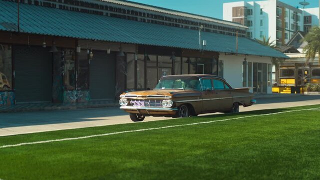 Retro yellow car standing on asphalt road at sunset
