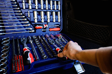 Socket wrench toolbox in the trunk of a black car. © Natallia