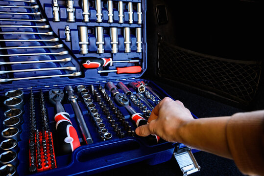 Socket wrench toolbox in the trunk of a black car.