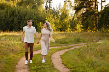 Fototapeta premium Relaxed Family Stroll Under Bright Sky. Parents And Children Wandering Through Peaceful Sunlit Field Combined. Tranquil Family Outing In Open Meadow With Trees And Smiling Faces