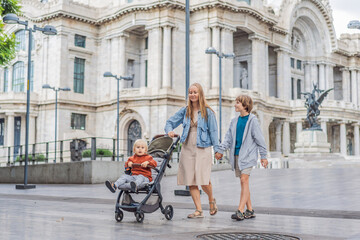 Obraz premium Mother tourist with her two sons in front of Palacio de Bellas Artes in Mexico City, enjoying family travel, architecture, and cultural heritage. Family travel and bonding concept