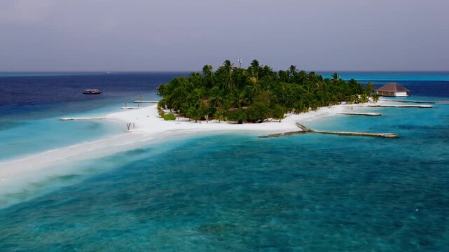 Aerial drone view of a tropical island paradise with overwater bungalows and clear blue ocean
