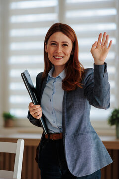 Woman waves goodbye before leaving office