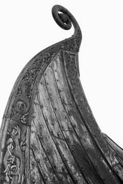 bow of the viking Oseberg longship with clinker built planks and artful wood engraving in black an white..