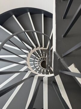 Spiral Staircase Symmetry: A gorgeous black and white view of a spiral staircase repeating down multiple floors with perfect symmetry.