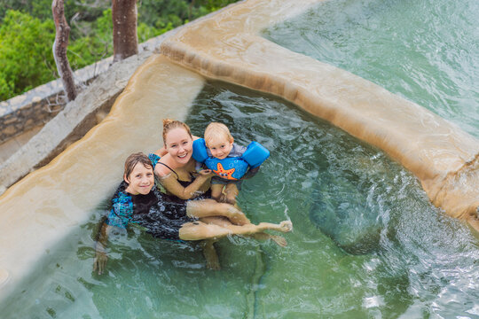 Mother with her toddler and teenage son bathing in the hot springs of Grutas Tolantongo, Mexico, enjoying family bonding, wellness, and outdoor adventure concept.