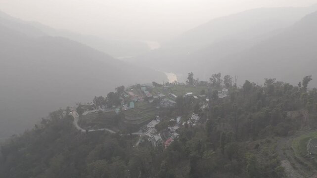 Aerial view of Kuee village in Tehri Garhwal, Uttarakhand, near Rishikesh, with the Ganga River flowing through Tota Ghati, surrounded by lower Himalayan hills and forests of sal, peepal, banyan.