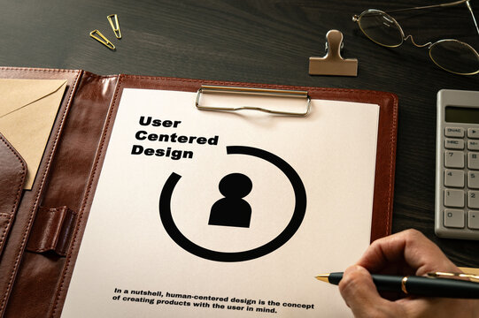 User Centered Design: Realistic mock-up mock placed on  with calculator, clips, pen. Contributor-created fictional business document for illustrative purposes.