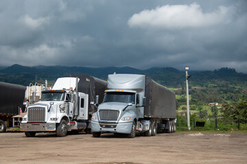 Cargo trucks parked on the side of a road in the Colombian countryside.