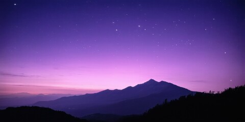Fototapeta premium Dark mountains silhouette against vibrant purple sky. Stars visible, creating peaceful nighttime scene. Calm beauty.
