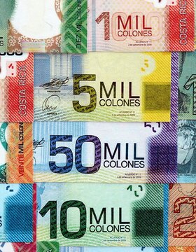 Costa Rican old and new colon money bills pile on table. Costa Rica banknotes of CRC currency close up. Concept of business, economy and banking in Costa Rica