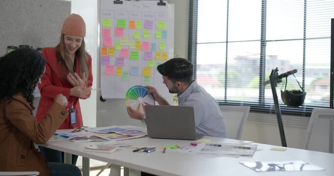 Diverse group of startup team engaging in brainstorming session, using sticky notes on glass wall to organize ideas, plan next steps. Creativity and collaborative spirit of modern entrepreneurial team