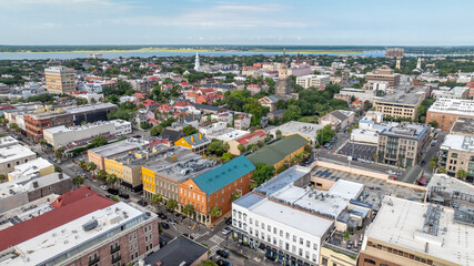 Fototapeta premium Aerial view of downtown Charleston, South Carolina skyline showcasing historic churches, colorful buildings, and neighborhoods during morning daylight in the lowcountry cityscape landscape