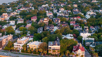 Fototapeta premium Aerial view showcasing downtown Charleston, South Carolina waterfront historic mansion homes and trees within South of Broad neighborhood in the lowcountry landscape during morning sunrise light