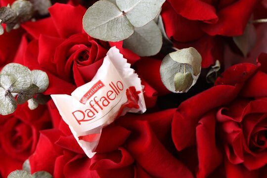 KYIV, UKRAINE - FEBRUARY 14, 2026 Raffaello candy on a red roses bouquet. Raffaello is a spherical coconut almond confection
