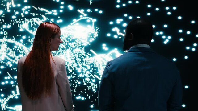 Engineering team monitoring AI model cognitive systems using AR projection, collaborating. RD tech startup coworkers brainstorming, using laptop to study neural network activity, camera B