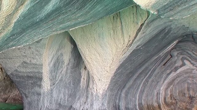 Observe the majestic Marble Caves of Patagonia, where nature's artistry paints swirling patterns of blue and grey marble, a timeless spectacle.