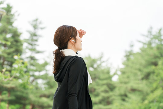 Women running, walking, jogging, or exercising in a park while wearing earphones (diet/sports)