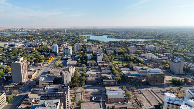 Regina, saskatchewan cityscape along rose street with downtown skyline, parkland and wascan a lake visible, autumn trees framing a harmonious urban and natural landscape