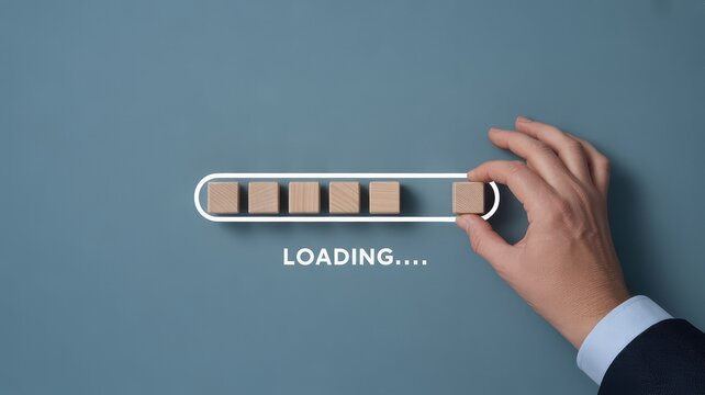 Businessman placing the final wooden block onto a loading bar symbolizing progress and completion of a complex project