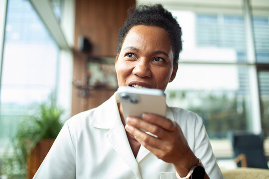 Woman using voice assistant on smartphone in modern office