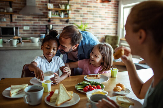 Family with two children sharing breakfast at home kitchen