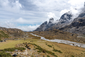 Fototapeta premium Scenic alpine landscapes along the Yading Big Kora and the famous Rock Trail in Daocheng Yading, Sichuan, China, featuring sacred snow mountains, high-altitude valleys, drifting clouds, glacial lakes,