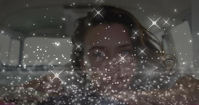 Vertical video: woman smiling, tilting in car as sparkles appearing across foreground for marketing